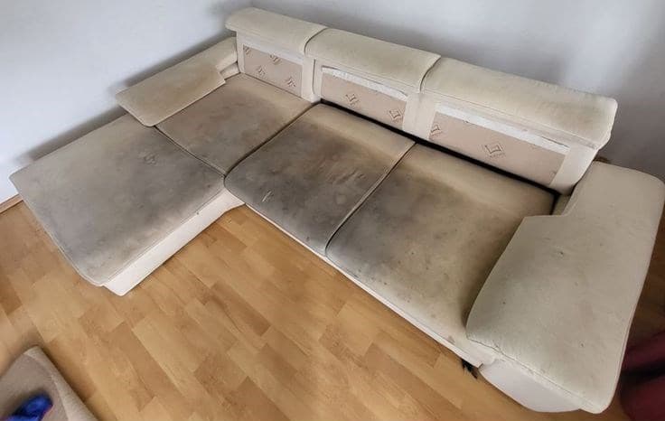 Sofá de canto com assentos encardidos e manchados, antes da higienização
